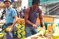 Seller splitting coconuts at a flea market Royalty Free Stock Photo